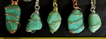 Amazonite wire wrapped tumbled stone pendants on necklaces. Amazonite is a green form of feldspar, sometimes bluish green. They are opaque stones with a little flash